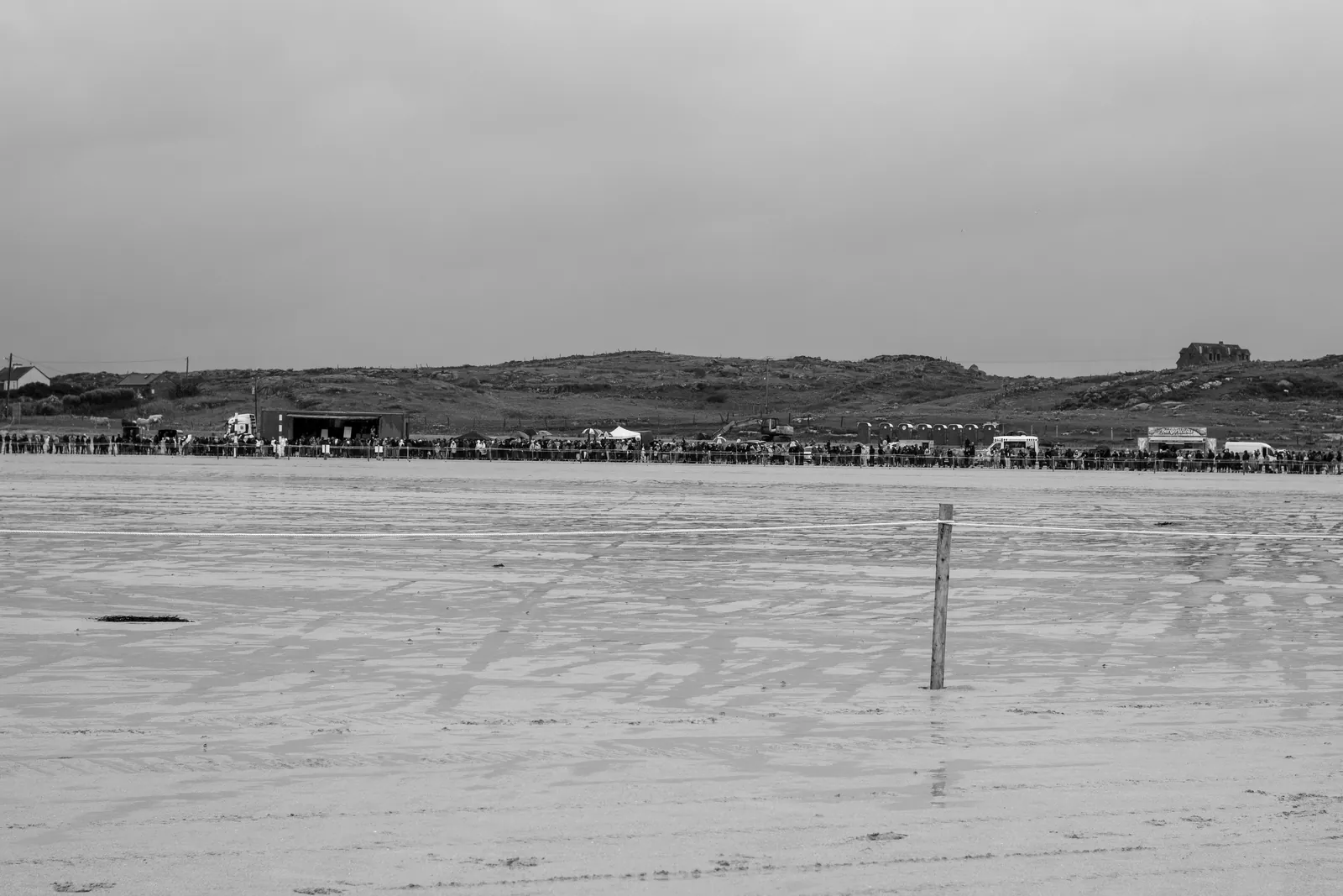 A long line of spectators, parked cars, food stalls and a stage stretched across the far edge of Omey Strand beneath low green hills.